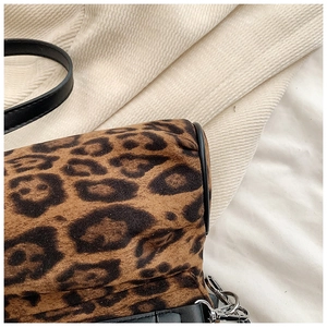 Detailed close-up of leopard print suede texture with black leather trim and silver hardware