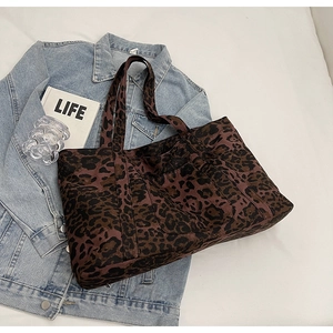 Detail of leopard print tote bag with side pocket shown in a lifestyle photography set