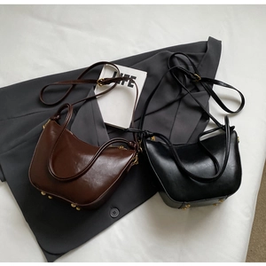 Detail of retro leather bucket bag bottom with protective gold-tone metal rivets