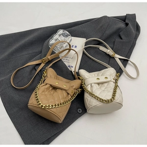 Quilted mini bucket bags in camel and off-white with gold chain handles and leather straps
