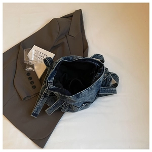 Detail of washed denim tote bag with multiple pockets and double shoulder straps