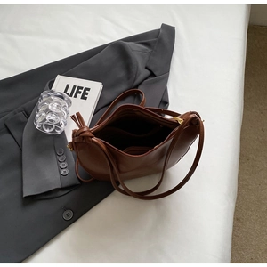 Detail view of the brown leather handbag's interior compartments and gold zipper hardware