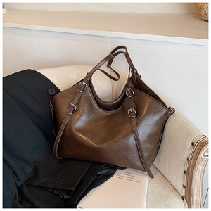 Detail of vintage brown tote bag with adjustable shoulder strap and magnetic closure