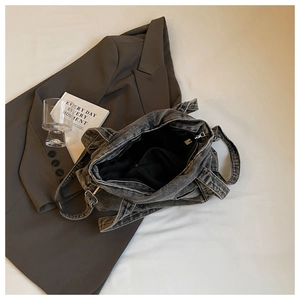 Detail of grey denim tote bag interior featuring large capacity and zipper pocket