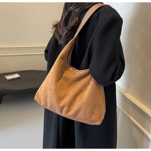 Détail de la texture en daim marron doux d'un grand sac à bandoulière hobo pour femmes
