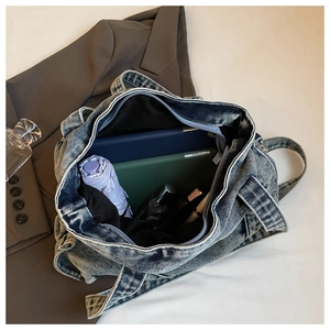 Macro shot of large capacity denim tote bag interior showing organized items and zipper