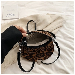 Internal view of leopard print saddle bag with inner zipper pocket and metallic clasp