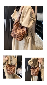 Detail view of stylish leopard print bucket bag with brown leather straps and metal logo