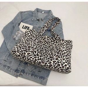 Detail shot of leopard print tote bag with front pocket and durable canvas handles
