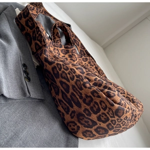 Detail of leopard print tote bag texture and soft fabric on a grey blazer background