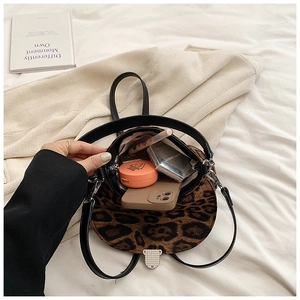 Internal view of leopard print crossbody bag showing storage for lipstick and phone