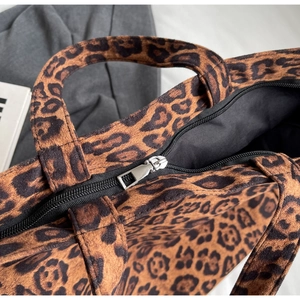 Detail of leopard print tote bag showing silver metal zipper and fabric texture