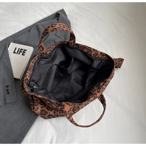 Detail view showing large leopard print tote bag interior with zipper and lining