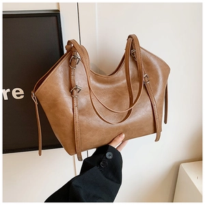 Detail view of brown vintage tote bag with adjustable shoulder strap and silver buckle