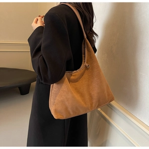 Sac hobo en daim marron, grande capacité et texture souple montrés portés