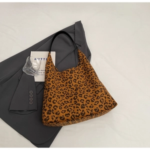 Détail du sac hobo avec imprimé léopard en toile et style de bandoulière en cuir noir