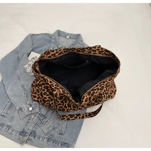 Detail view of leopard print tote bag with black inner lining and zipper pocket