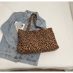 Detailed close-up of the large leopard print tote bag on a stylish denim fabric background