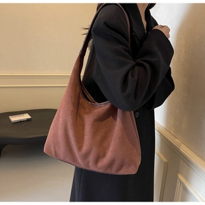 Gros plan d'un sac bandoulière en daim marron avec bandoulière en cuir pour mode vintage
