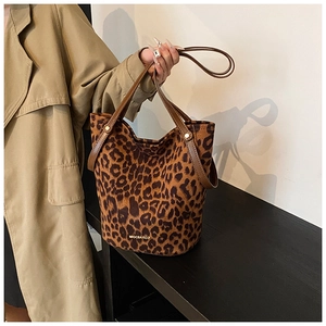 Detail of leopard print bucket bag with suede texture and metallic logo branding