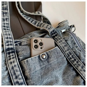Detailed macro view of vintage snowflake wash denim tote with metal zipper and snap pocket
