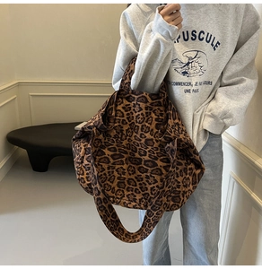 Close-up side view of a large leopard print canvas tote bag carried over the shoulder
