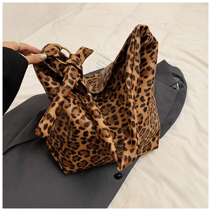Detail of leopard print tote bag with golden metal ring and knotted strap design