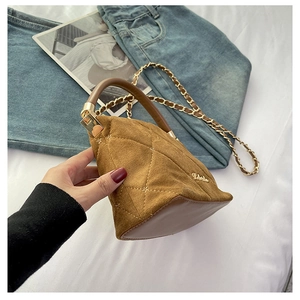 Close-up of brown quilted faux suede handbag with chain strap and metallic logo