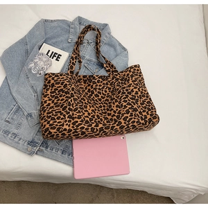 Detailed top view of large leopard print tote bag next to a tablet for size comparison