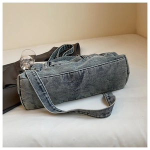 Detail of vintage blue washed denim tote bag showing soft texture and wide shoulder strap
