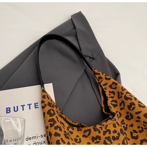 Gros plan du sac cabas rétro à imprimé léopard avec bandoulière noire sur fond gris