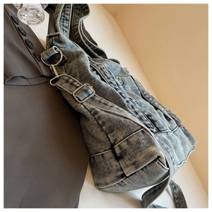Close-up of washed denim tote bag showing metal buckle and retro fabric texture