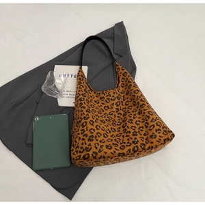 Vue à plat du sac cabas vintage imprimé léopard avec blazer et livre pour look urbain