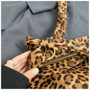 Close-up of leopard print canvas bag with gold ring accents and detailed texture