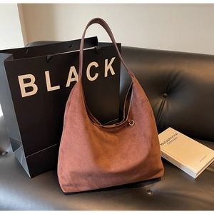Détail du sac cabas en daim marron foncé avec boucle métallique réglable et texture mate douce