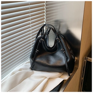 Detail of a black large-capacity PU leather tote bag with metallic rings and soft folds
