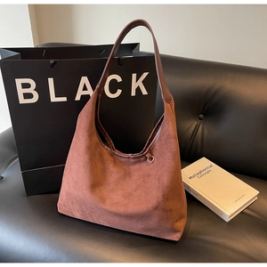 Détail du sac hobo en daim marron avec anneau métallique poli et texture souple