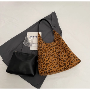 Détail d'un sac cabas à imprimé léopard et d'une pochette zippée sur une veste