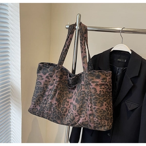 Macro detail of leopard print tote bag texture and convenient front pocket design