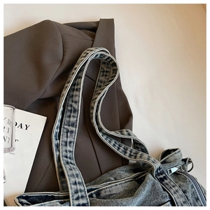 Detail of vintage denim tote bag with heavy-duty washed fabric and silver metal zipper