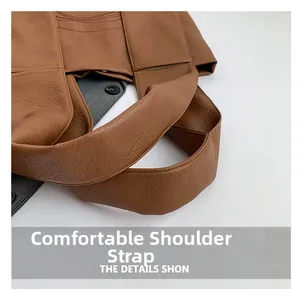 Detail view of the comfortable wide shoulder strap on this vintage caramel tote bag