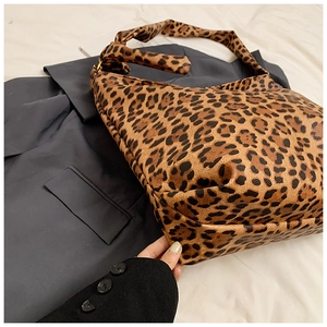 Detail showing leopard print canvas texture and stylish knot design on shoulder strap