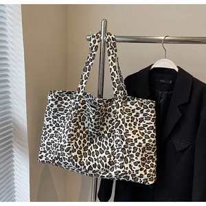Close-up of leopard print canvas tote bag featuring a front pocket and stylish shoulder strap