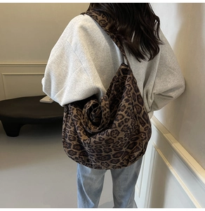 Macro view of leopard print canvas tote bag showing texture and crossbody strap details