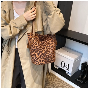 Detailed close-up of leopard print bucket bag with brown leather strap and logo detail