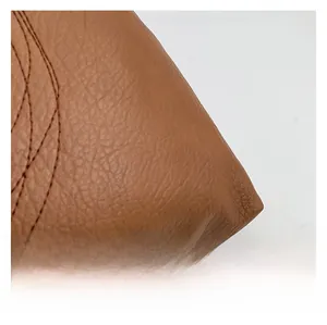 Close-up of brown litchi grain leather texture and fine stitching on the stylish handbag