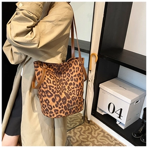 Detail of leopard print velvet bucket bag with brown leather straps and gold logo
