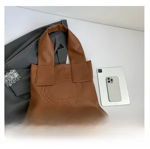 Detail of dark brown retro tote bag with concentric circular stitching and wide shoulder strap