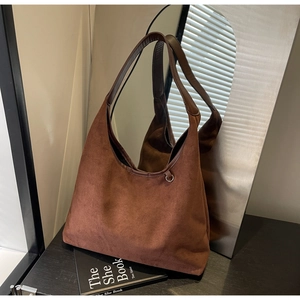 Détail du sac hobo en daim marron vintage avec anneau métallique et bandoulière élégante