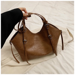 Detailed view of the brown PU leather tote bag with lychee texture and metal buckle